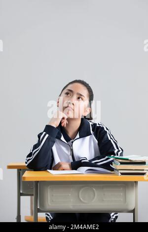 Chinese student thinking in classroom Stock Photo