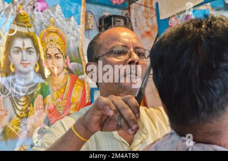 Hairdresser working in his fancy shop on the market in Along Stock Photo