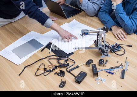 Confident Chinese designers checking a robotic arm Stock Photo