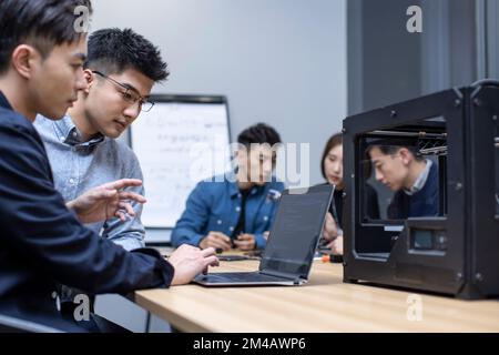 Confident Chinese designers using a 3D printer Stock Photo