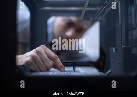 Confident Chinese designer using a 3D printer Stock Photo