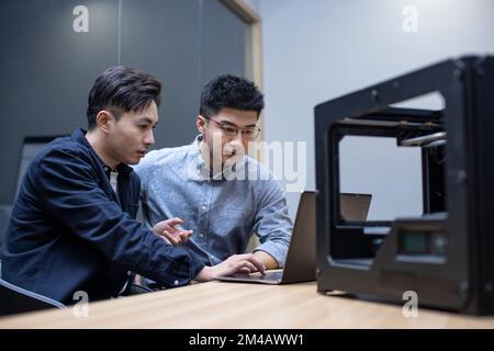 Confident Chinese designers using a 3D printer Stock Photo