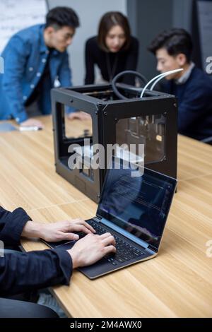Confident Chinese designers using a 3D printer Stock Photo