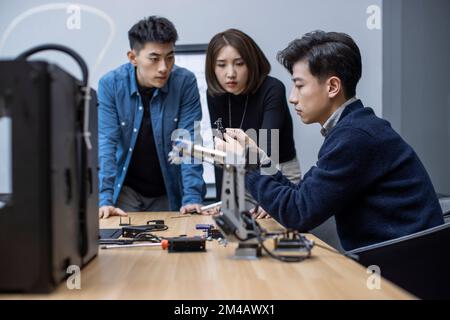Confident Chinese designers using a 3D printer Stock Photo