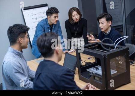 Confident Chinese designers using a 3D printer Stock Photo