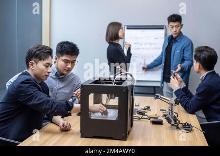 Confident Chinese designers using a 3D printer Stock Photo