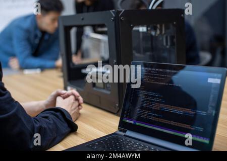 Confident Chinese designers using a 3D printer Stock Photo