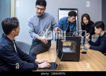 Confident Chinese designers using a 3D printer Stock Photo