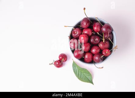 juicy red cherries in a gray bowl on a pink background. Top view and copy space image Stock Photo