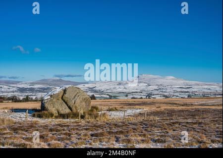 This winter image is of the Yorkshire Dales Ingleborough Peak as seen from the ice age relic the Big Stone on Burnmoor above the town of High Bentham Stock Photo