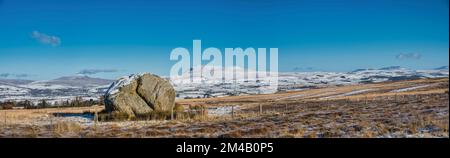 This winter image is of the Yorkshire Dales Three Peaks as seen from the ice age relic the Big Stone on Burnmoor above the town of High Bentham Stock Photo