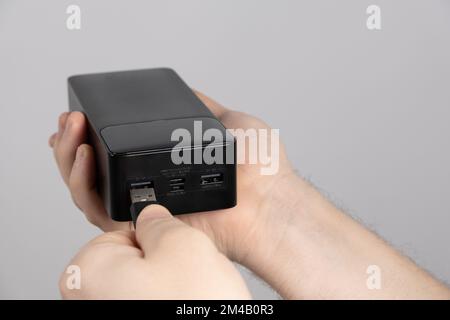 Connecting the cord to the power bank. Charging gadgets from the power bank. Stock Photo