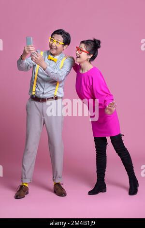 Excited senior Chinese couple holding a smart phone Stock Photo