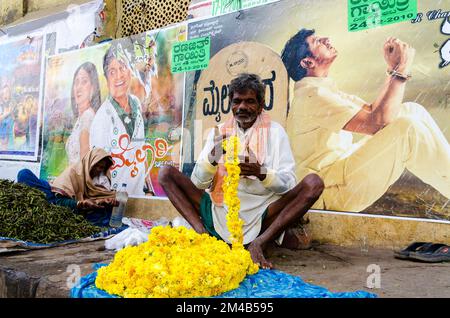 Cinema posters and plakates at a broken down house wall, a tomato seller in front Stock Photo