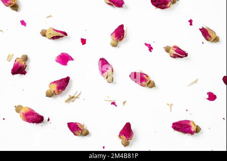 Flat lay dry rose buds on a white background. Concept pattern herbal tea. Top view. Stock Photo