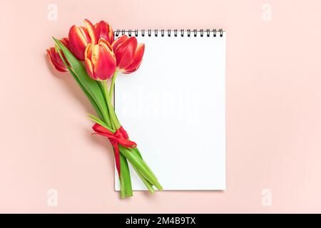 Bouquet of red tulips, gift box heart, notepad on pink background Top view Flat lay Holiday greeting card Happy moter's day, 8 March, Valentine's day, Stock Photo