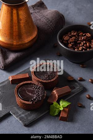 mini chocolate tarts with coffee beans on a dark background. Close up image Stock Photo