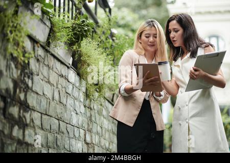 Business colleagues checking details in report on tablet computer Stock Photo