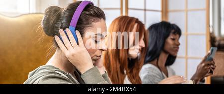 Horizontal banner or header with multicultural female friends having fun individually doing different things - Concept of incommunicability between pe Stock Photo