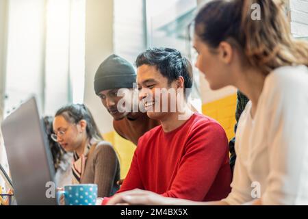 Young co-workers multiethnic team planning a new startup - Happy computer programmers working on a new project in creative coworking office - Bright f Stock Photo