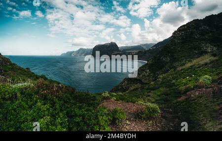 a body of water surrounded by a lush green hillside Stock Photo
