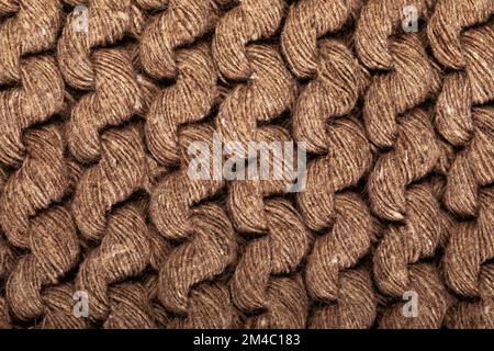 Detail of the handmade knitted pattern. Background and texture of knitted woolen or cotton fabric. Close-up. Brown color. Stock Photo