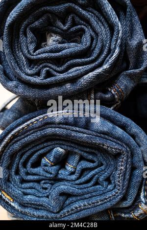 Jeans rolled up and stacked. Concept of the trading industry, sales. Stock Photo