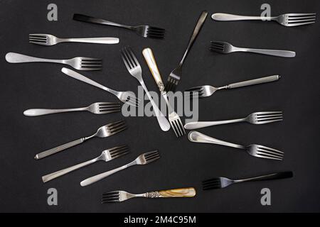 A bunch of assorted forks lying on a black background Stock Photo