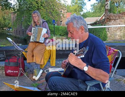 Musicians on the towpath of the Peak Forest canal, lock flight, Marple, Stockport, Cheshire, England, UK, SK6 5LD Stock Photo