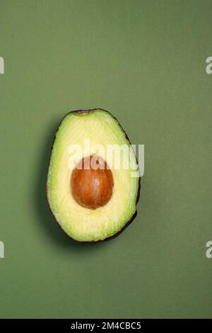 close up of fresh ripe avocado on green background, copy space  Stock Photo