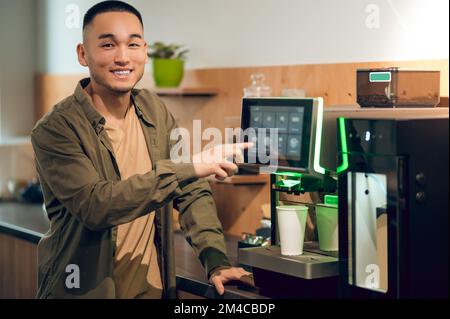 Corporate worker making a caffeinated drink in the office kitchen Stock Photo