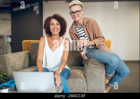 Joyful company workers posing for the camera at work Stock Photo