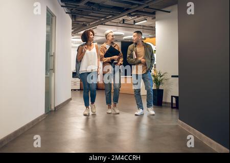 Office workers having a conversation in the company corridor Stock Photo