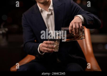 Elegant Chinese man drinking whiskey Stock Photo