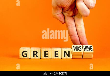 Green or greenwashing symbol. Concept words Green and Greenwashing on wooden cubes. Businessman hand. Beautiful orange table orange background. Busine Stock Photo