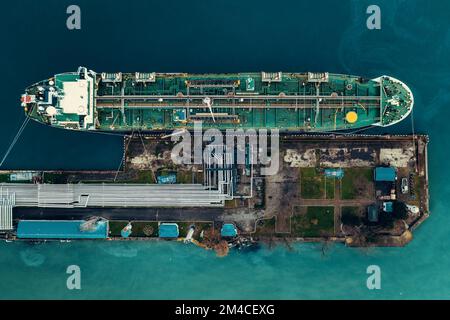 Oil tanker ship in industrial port aerial top view, logistic and transportation oil and gas industry. Stock Photo