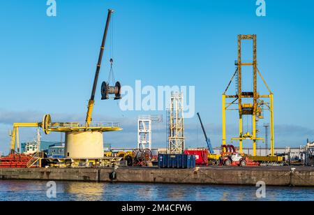 Industrial crane lifting cable wheel on dockside, Leith Docks, Edinburgh, Scotland, UK Stock Photo