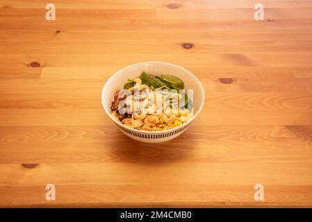 A wonderful bowl of vegan salad with bean sprouts, cashew nuts, corn and spinach Stock Photo