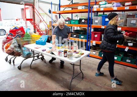 Volunteers Ruth Brown and Phil Bates unpack and sort food item donations from the public at the Warehouse. The Welcome Centre warehouse in Huddersfiel Stock Photo