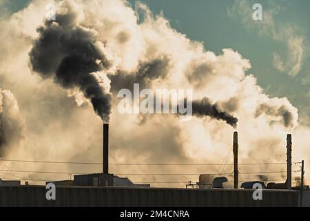 Smoke and fumes emitted from factory smokestacks. Stock Photo