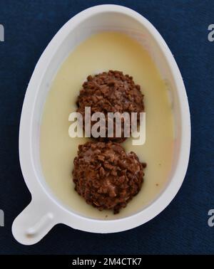 half of the Kinder Joy egg on the blue background Stock Photo
