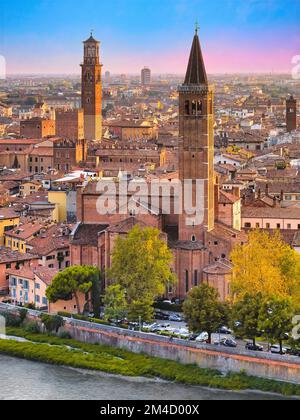 Verona, Veneto, Italy. View from San Pietro hill at sunset. In the foreground, the bell tower of the ancient church of Santa Anastasia. Stock Photo
