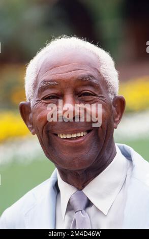 Older African-American man headshot with grey hair smiling at the camera Stock Photo