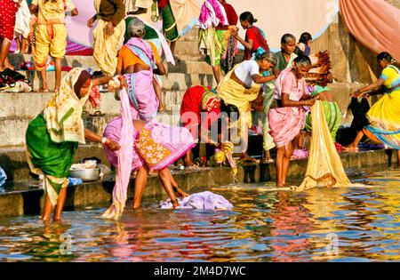 Woman washing cloths the traditional way on the banks of the river Godavari Stock Photo