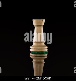 Wooden white chess rook isolated at dark background with transparent reflection on the floor Stock Photo
