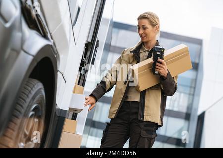 Courier Delivering Packages by Van with barcode scanner Stock Photo