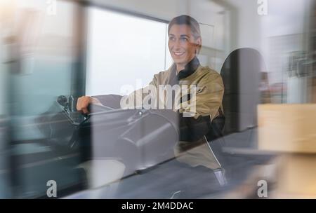 Smiling Courier woman sitting in the car as a driver with motion blur Stock Photo