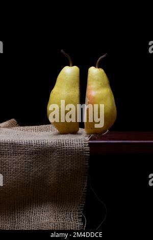Two pieces of sliced ripe pears on a wooden shelf Stock Photo