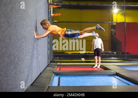 Tween boy jumping on trampoline on indoor inflatable playground Stock Photo