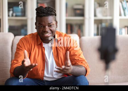 Young African male blogger in casual clothes streaming video online Stock Photo